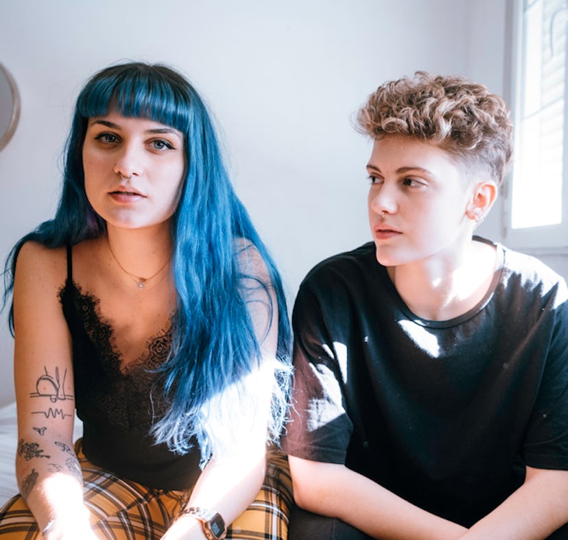 2 young people sitting awkwardly because they have a quincunx in their birth chart, which could be t...