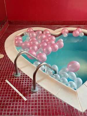 Heart-shaped tub with pink balloons in it, at Cove Haven Resorts