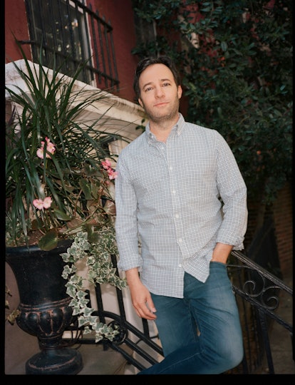 Danny Strong leaning against a staircase outdoors