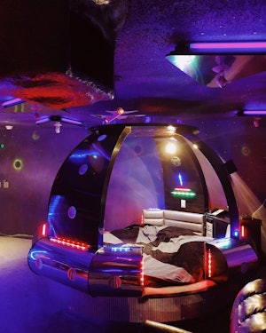 A space-ship-shaped bed  in a hotel room 