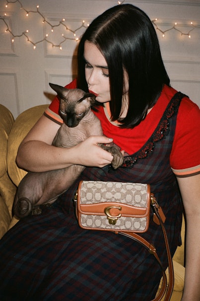 Barbie Ferreira with her sphynx cat and Coach's bag in red T-shirt and black dress for Coach’s Holid...