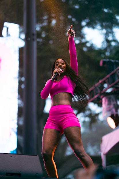  Flo Milli performing outdoors in a long-sleeved pink sports top and pink bicycle shorts 