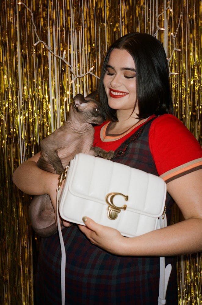 Barbie Ferreira with her sphynx cat and Coach's white medium sized bag for Coach’s Holiday 2021 Camp...