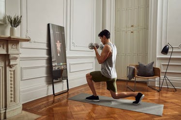 A man lifting weights in front of the Mirror.