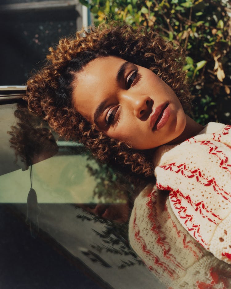 Alexandra Shipp from movie "Tick, tick... Boom!" close-up laying on the car