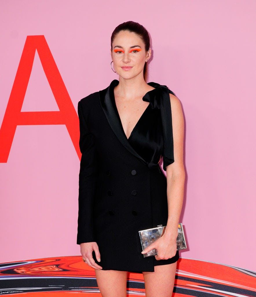 Shailene Woodley with neon orange eye makeup and a simple black dress.