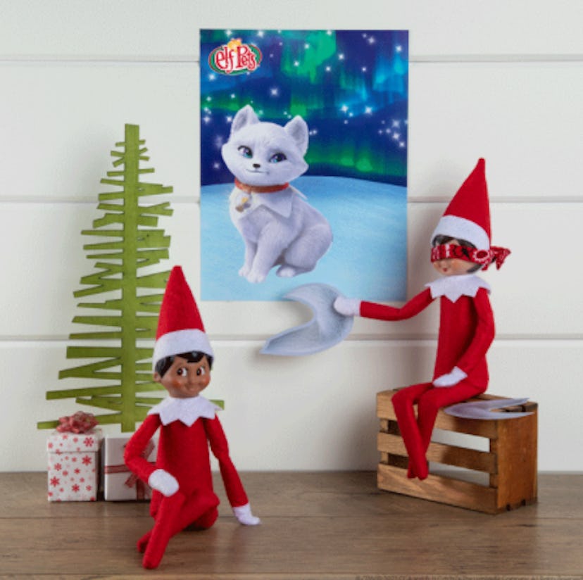 Two elves on the shelf playing pin the tail game.