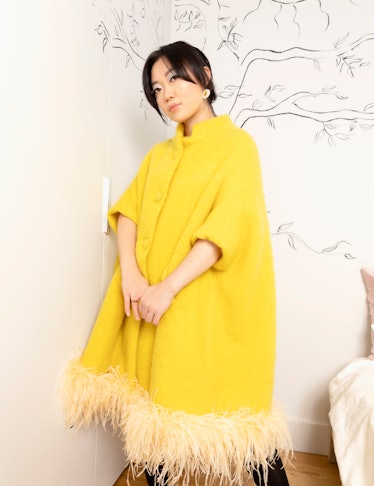 Olivia Cheng at home, wearing a Dauphinette coat and earrings. 