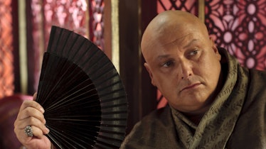 Conleth Hill holding fan as Varys in Game of Thrones