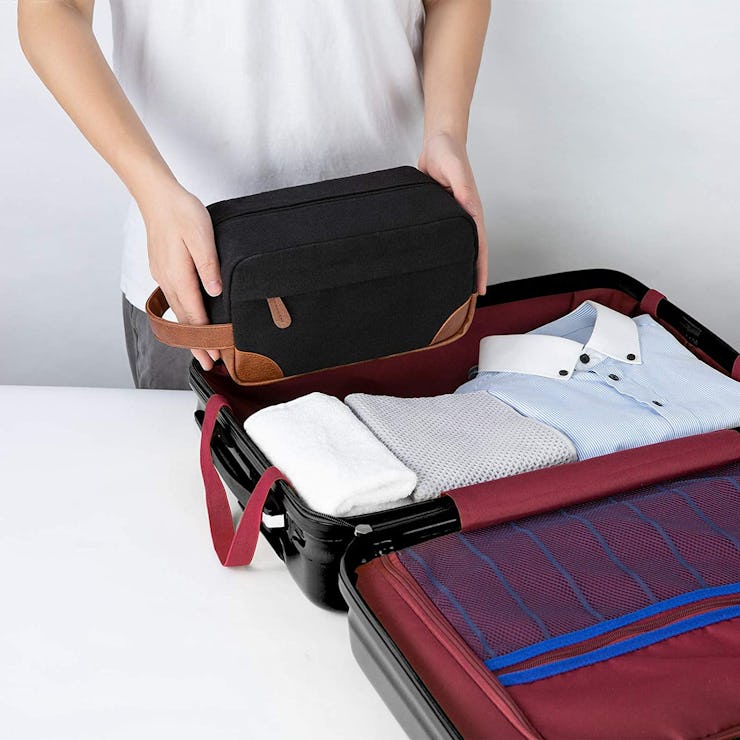A man packing clothes and using the Vorspack Toiletry Bag Hanging Dopp Kit