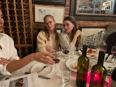 Pookie Burch and Ashley Olsen posing for a photo while sitting next to a served table