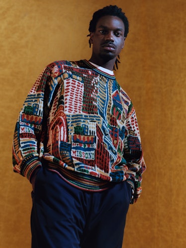 A model in a sweater with multicolored patterns