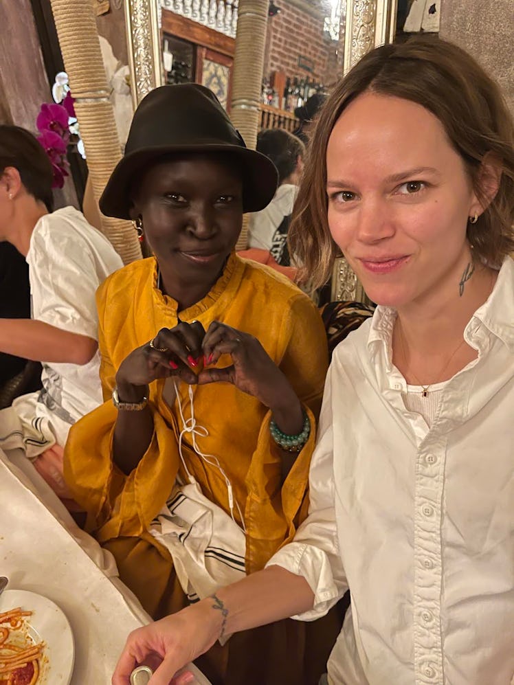 Alek Wek and Freja Beha Erichsen posing for a photo at a dinner table