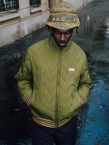 A model in a green Missoni Supreme branded puffer jacket and bucket hat