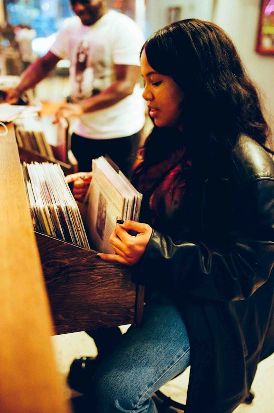 Baby Rose flips through records at Legacy record shop in Brooklyn.