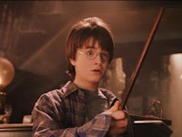 Harry Potter in pajamas holding his wand 
