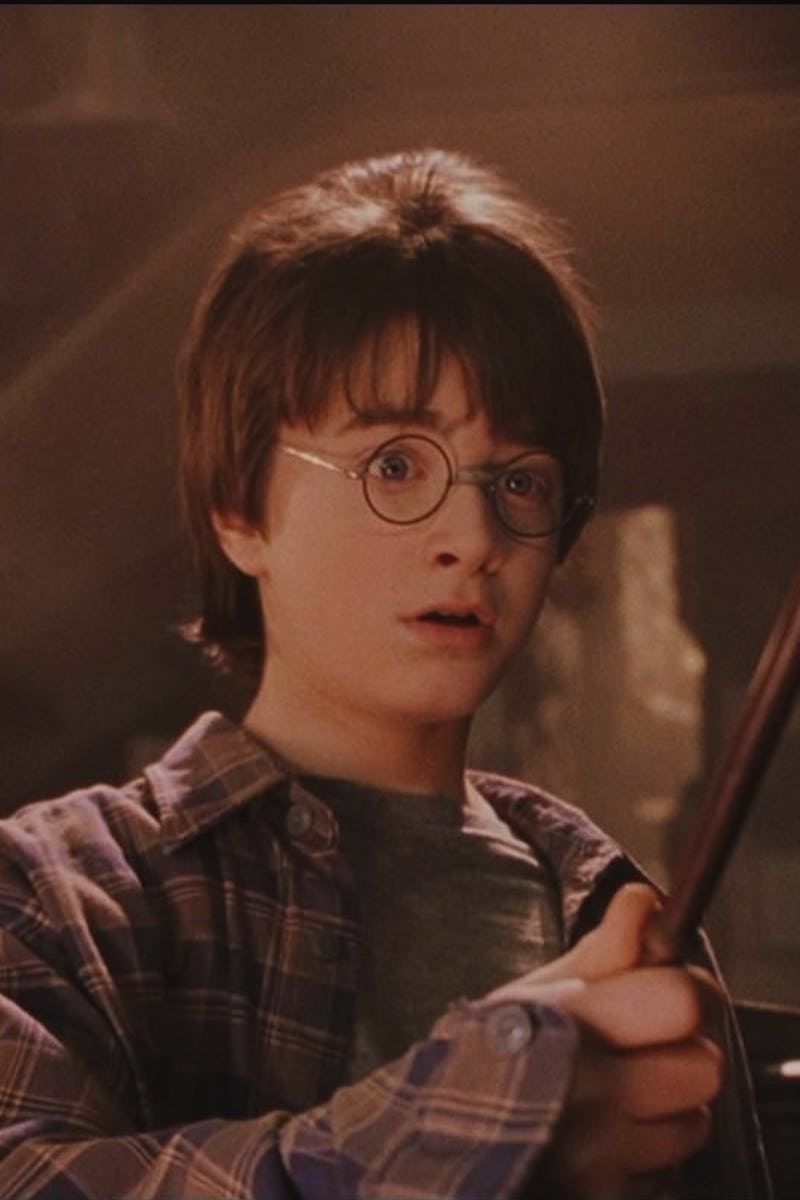Harry Potter in pajamas holding his wand 