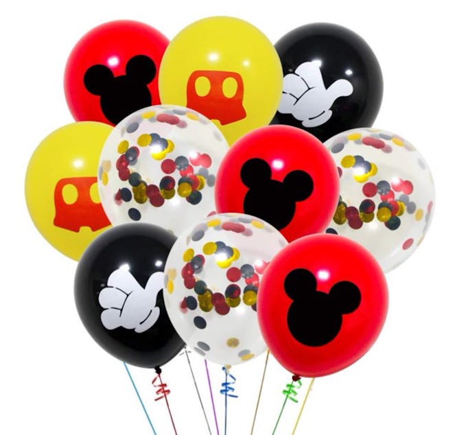 Image of a bunch of red, yellow, black and translucent latex balloons with confetti and Mickey Mouse...