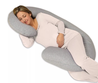 Pregnant woman sleeping on her side using pregnancy body pillow
