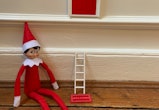 Elf on the Shelf arrival idea: place them under a little faux door with wreathh