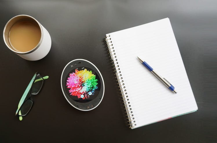 The egg-shaped Cyrcle Phone on a desk next to coffee and a notepad.