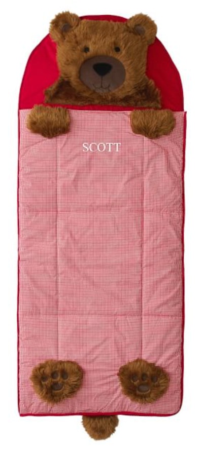 Image of a red kid's sleeping bag with teddy bear pillow "head." 