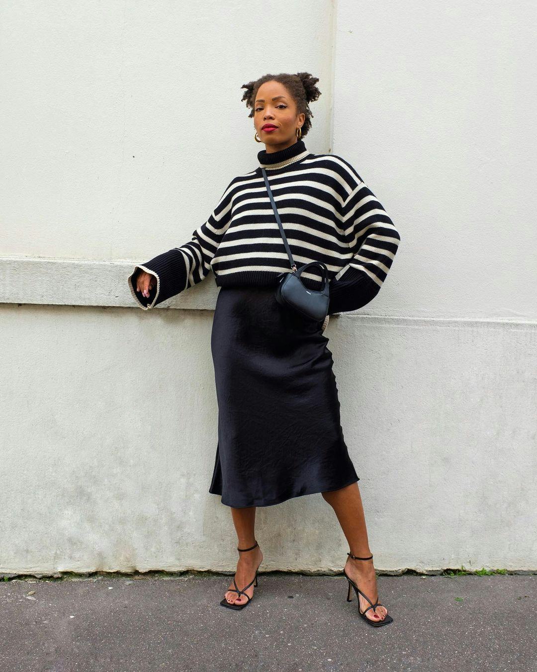 Ellie Delphine wearing navy and white striped sweater over a blue slip dress.