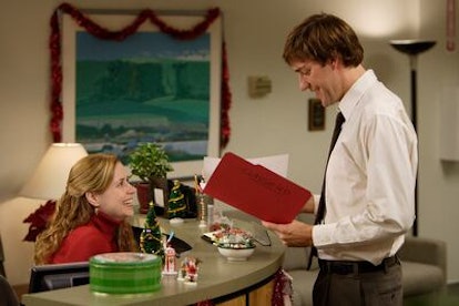 Jim and Pam of The Office smile at the reception desk