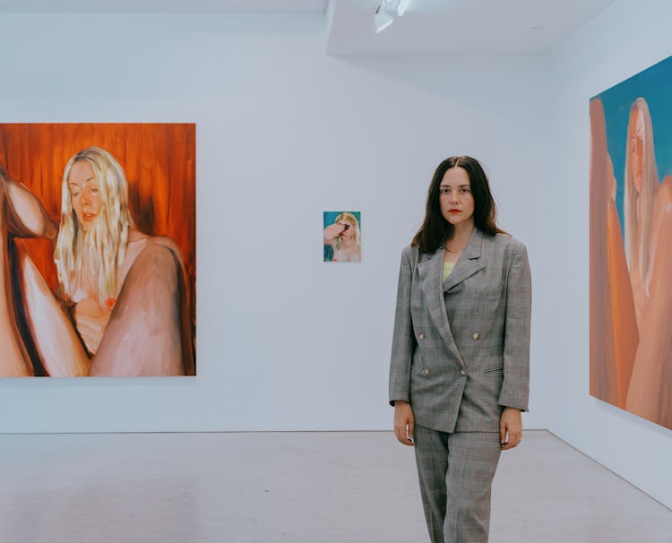 Jenna Gribbon at Fredericks & Freiser gallery posing with recent works in the background 