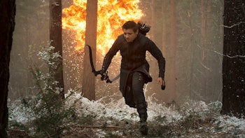 Jeremy Renner as Hawkeye running through the woods while being attacked 