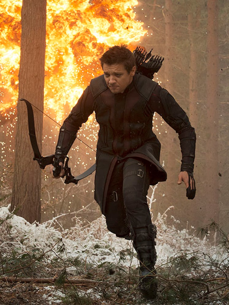 Jeremy Renner as Hawkeye running through the woods while being attacked 