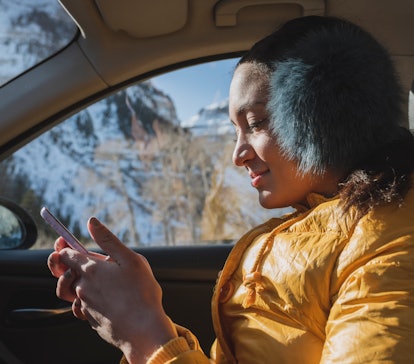 Young Aries on her phone in the car on December 29, 2021, the best day of the month for her zodiac s...