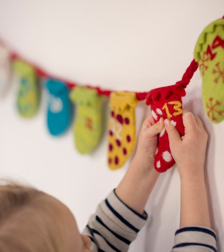 A child opens day 13 in a Christmas Countdown calendar.