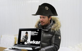 Bryan Goldberg wearing Napoleons hat while holding a laptop with his picture on it.