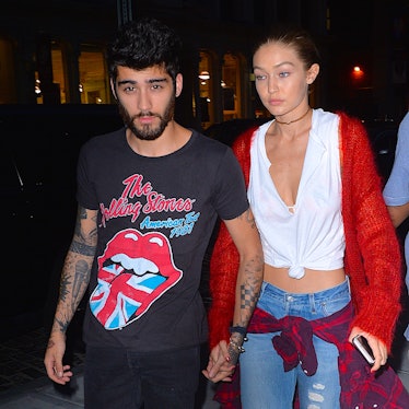 Zayn Malik in a black shirt with 'The Rolling Stones' print and Gigi Hadid in a white shirt, red swe...