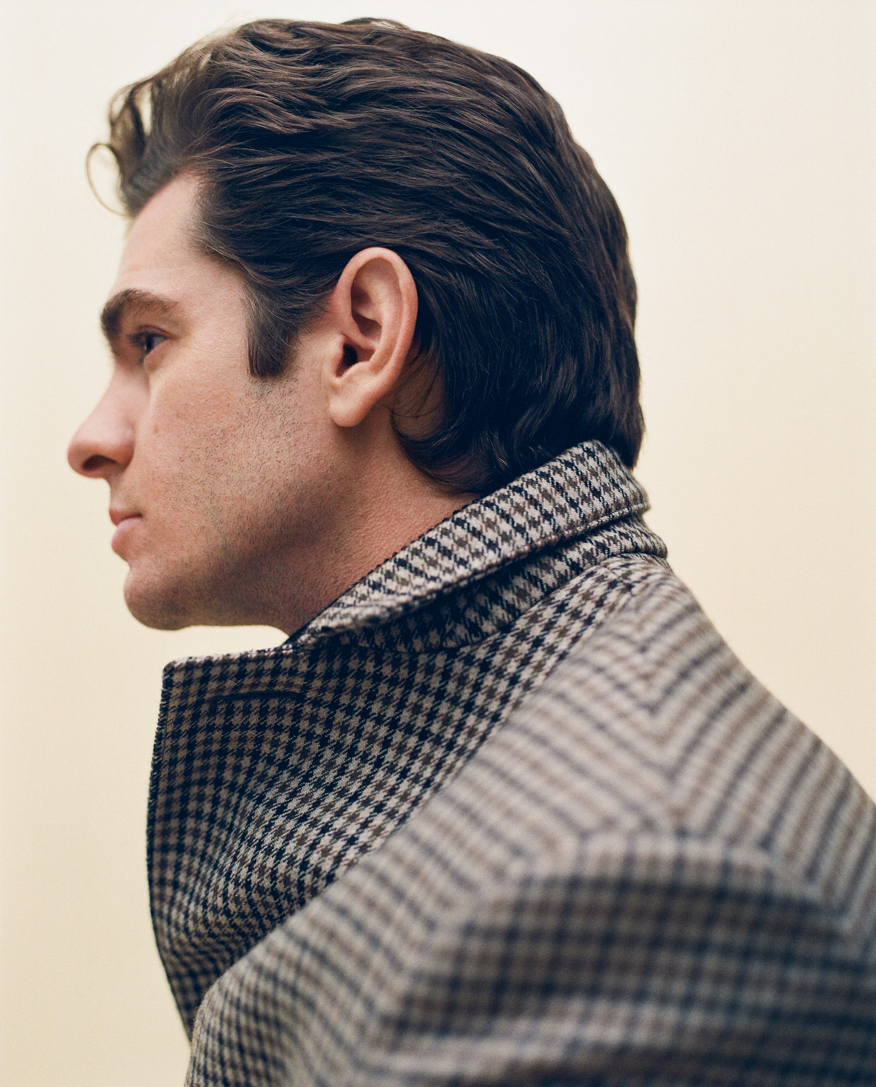 A side photo of Andrew Garfield in a Celine by Hedi Slimane coat in brown