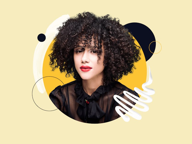 Nathalie Emmanuel in a sheer black top and red lipstick with black curly hair