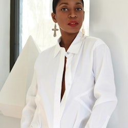 Rajni Jacques wearing a white button-down and jeans.