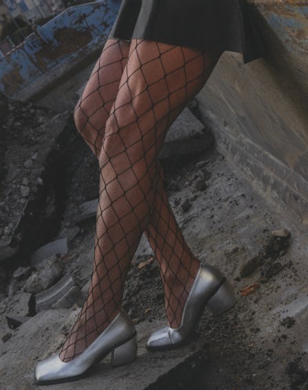 a man's legs wearing fishnet stockings and silver high heels