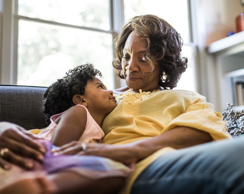 Grandmother and granddaughter cuddling on couch