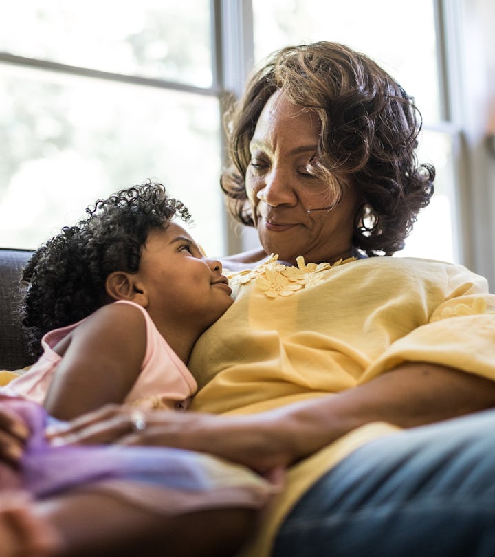 Grandmother and granddaughter cuddling on couch