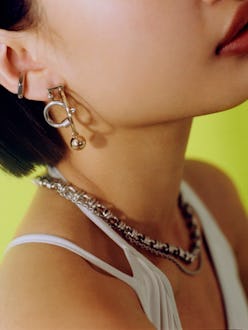 Model wears Justine Clenquet's silver and gold jewelry pieces.