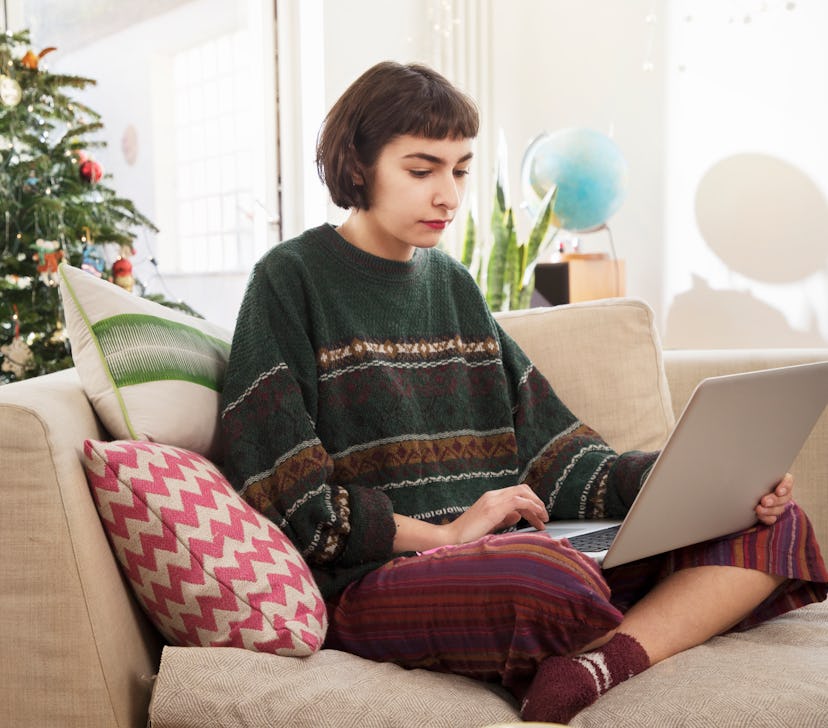 Aries woman on laptop reading her Christmas 2021 horoscope.