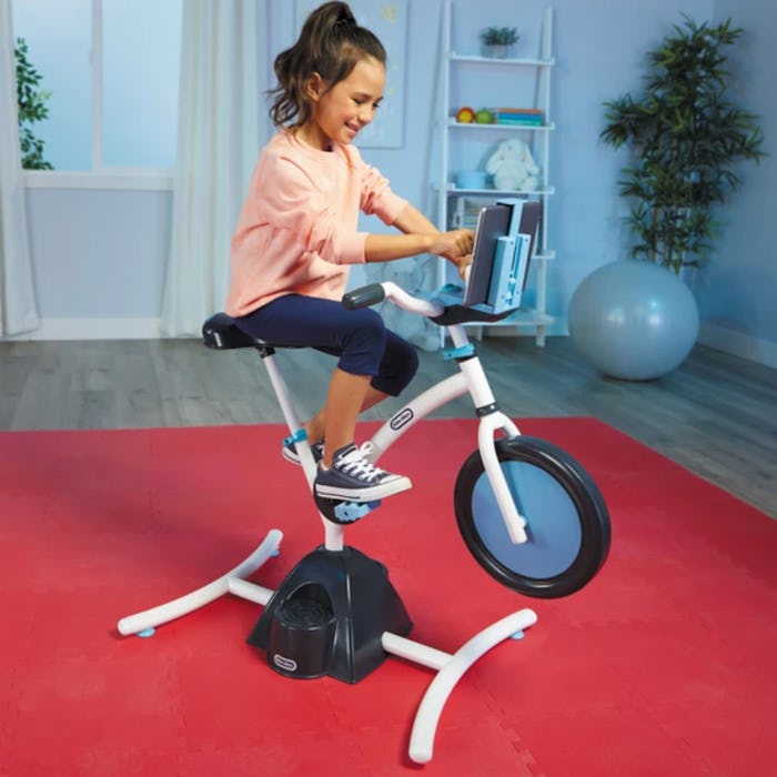 A young girl rides on the Little Tikes Pelican Explore & Fit Cycle