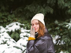 Young woman holding her cheek in the snow amid the 2021 winter solstice with its beautiful spiritual...