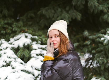 Young woman holding her cheek in the snow amid the 2021 winter solstice with its beautiful spiritual...