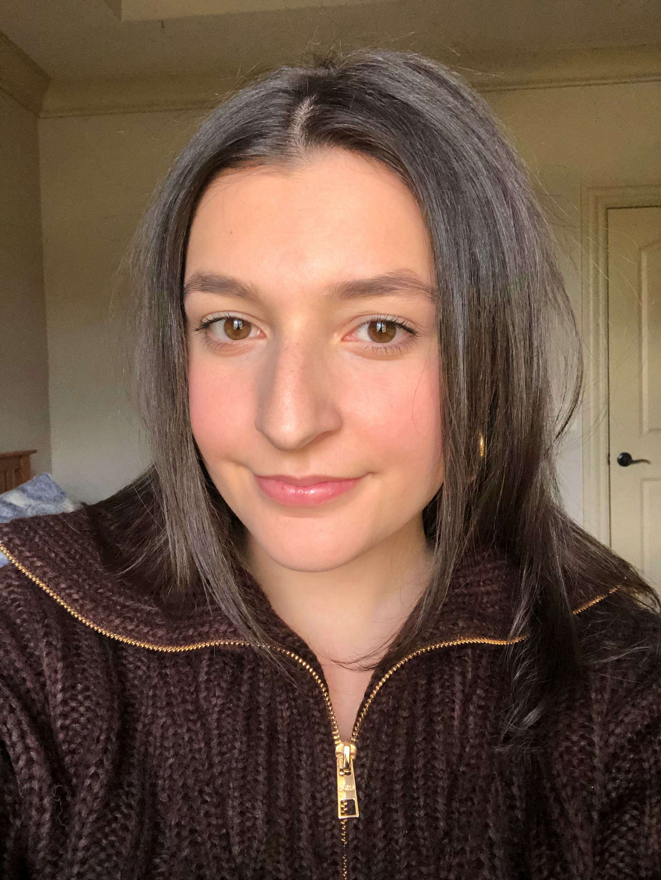 A woman with Rare Beauty's blush on her cheeks 