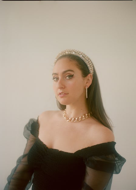 the comedian Catherine Cohen wearing a black dress with tulle sleeves and a sparkly silver headband
