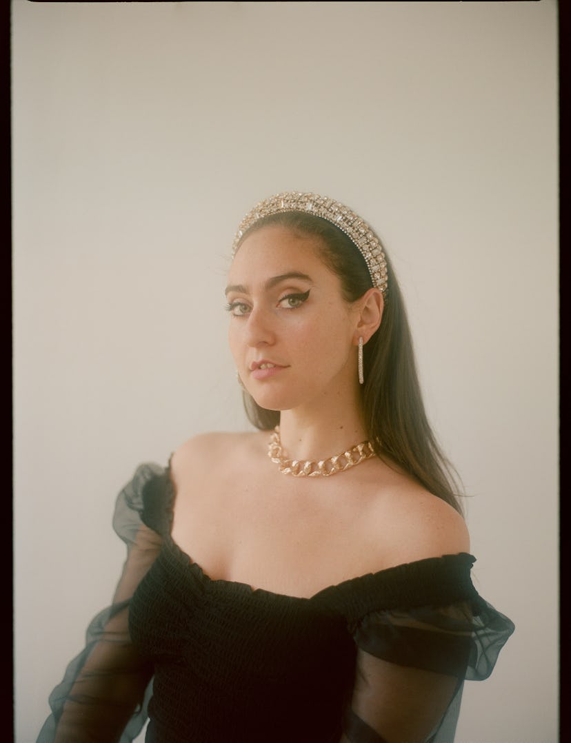 the comedian Catherine Cohen wearing a black dress with tulle sleeves and a sparkly silver headband