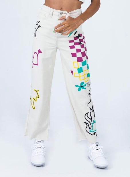 Model wearing graphic, colorful jeans in white from Princess Polly.